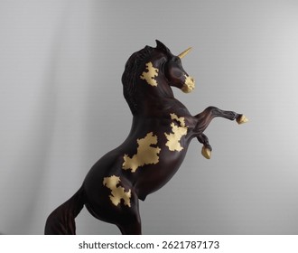Vista lateral del modelo de unicornio dorado y marrón 