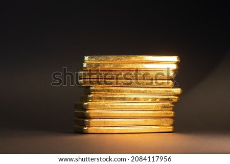 Gold bullion bars on black background. Stack of large cast investment gold ingots. Swiss gold. Business and finance. Investing into precious metals.