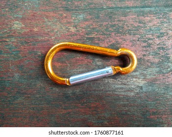 Gold Carabiner Stainless On The Wooden Background