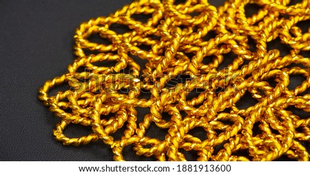 Gold chain to be worn around the neck. A chain is a sequential assembly of connected parts, made of gold, with an overall character similar to that of rope in that it is flexible and curved