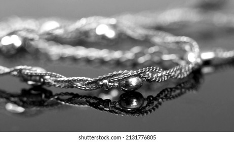 Gold Chain On A Black Mirror Surface