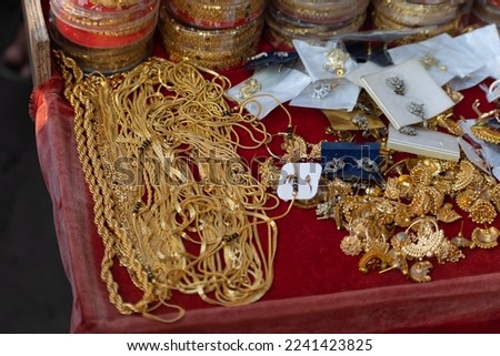 Gold chains and earrings  kept on a table. Jeweler, gold smith, fake, imitation, shine, real, pure, purity, carat, thief, theft, robbery, bank, locker, safety, fashion, accessory, layers, earrings.