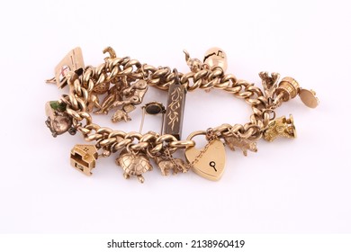 A Gold Charm Bracelet On A White Background.