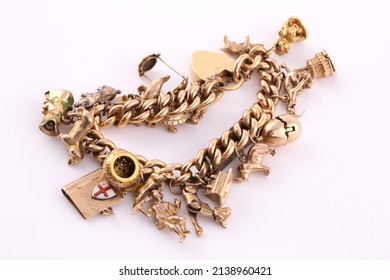 A Gold Charm Bracelet On A White Background.