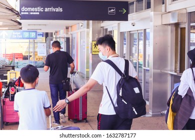 Gold Coast, Australia January 30 2020: Asian Family At Gold Coast Airport With Masks On And Luggage Queensland.