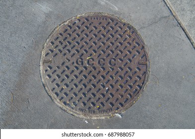 Gold Coast, Australia - July 12, 2017: Manhole Cover Bearing The Acronym Of The Gold Coast City Council.