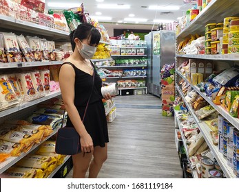 Gold Coast, Australia - March 21, 2020: Asian Female Wears Protective Medical Mask In Asian Grocery Store Amid Coronavirus Fears, Supermarket Safety, Health Hygiene And Pandemic Concept, Covid 19 Safe