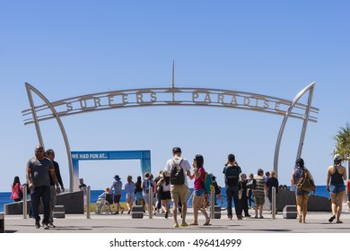 Gold Coast, Australia - September 22, 2016: View of many tourists crossing the road and the Surfers Paradise arch, the main entrance to the beach.