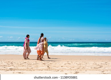 Gold Coast, Queensland, Australia - April 9, 2015:  Indian Family Women Grandmother And Two Daugthers Wear Colorful Traditional Clothes Sari Walking Barefoot On Beach In Sunny Summer Day