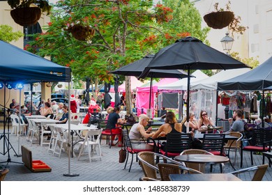 GOLD COAST, QUEENSLAND, AUSTRALIA - DECEMBER, 2018:  People Sitting In The Cafes And Enjoying Food And Conversation, Near Emerald Lakes Market.