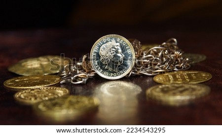Gold coin 10 pounds Great Britain Queen Elizabeth 2 on the background of jewelry and gold coins of Europe selective focus finance background