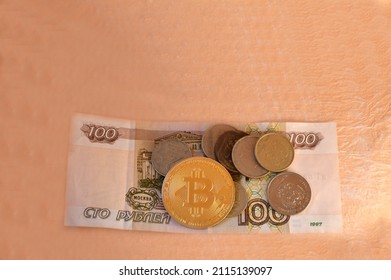 Gold Coin Bitcoin And Russian Money, Rubles And Coins On A Gentle Peach Background. E-currency Mining Investment Concept