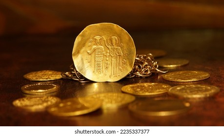 Gold coin histamenon 13th century Byzantium on the background of vintage gold coins and chains selective focus money abstraction - Shutterstock ID 2235337377