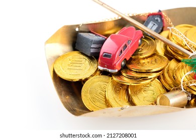 Gold coins in the weighing pan and car house model