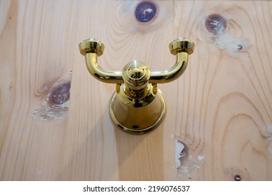 Gold Colored Coat Hook Mounted On The Wooden Door. Luxurious Bathroom Coat Hook.