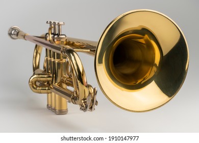 Gold colored trumpet as an isolated musical instrument against a white background in a studio