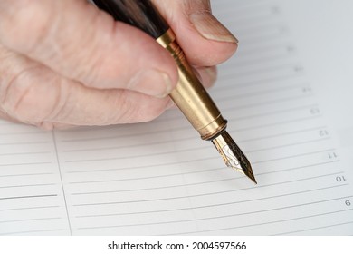 Gold Coloured Fountain Ink Pen In Senior Woman Hand About To Write Something On Empty Daily Planner Page, Closeup Detail