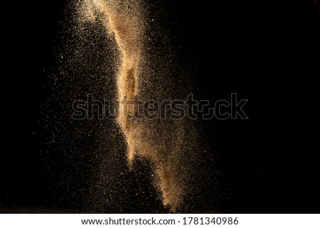 Gold confetti sand falling and scatter on black space.