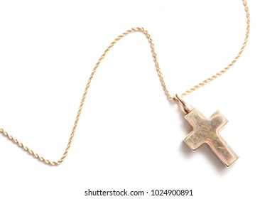 Gold Cross Necklace Shot Against A White Background