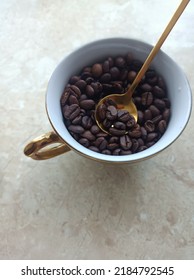 Gold Cup Of Coffee Full Of Coffee Beans Whit Gold Spoon Inside