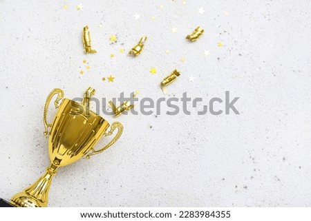 Gold cup with serpentine and stars on light background