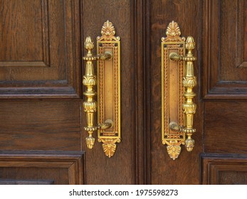 Gold Curly Iron Doorknob On A Wooden Front Door. Vintage, Close-up. Antique Charm. Selective Focus