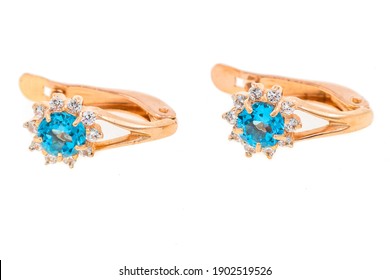 gold earrings with blue stone on white background.  - Shutterstock ID 1902519526