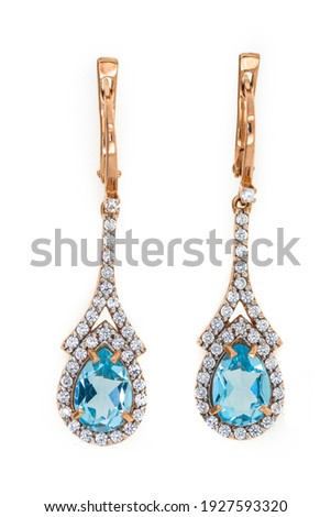 Gold earrings close up on a white background
