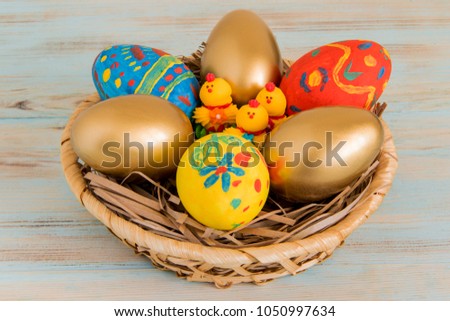 Gold Easter eggs in a basket with yellow baby chicken Easter conceptual picture