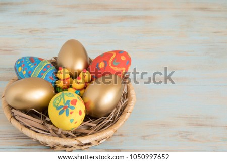Gold Easter eggs in a basket with yellow baby chicken Easter conceptual picture with copyspace