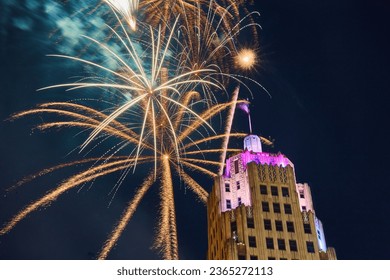 Gold fireworks behind Lincoln Tower downtown Fort Wayne on 4th of July with purple lights - Shutterstock ID 2365272113