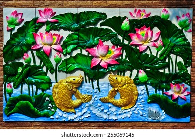 Gold fishes and lotus Thai stucco on the temple wall - Powered by Shutterstock