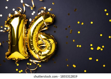 Gold foil balloon number, digit sixteen. Birthday greeting card, inscription 16. Anniversary celebration event. Banner. Stylish golden numeral, light bokeh, glitter, black background. Numerical digit.