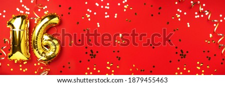 Gold foil balloon number, digit sixteen. Birthday greeting card, inscription 16. Anniversary celebration event. Banner. Stylish golden numeral, light bokeh, glitter, red background. Numerical digit.