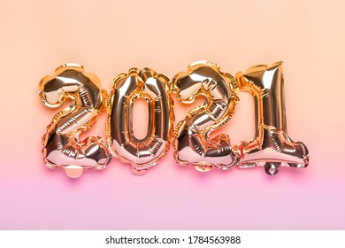 Gold foil balloons numeral 2021 isolated on beige background Flat lay composition Top view Happy New year 2021 concept  Holiday card - Shutterstock ID 1784563988