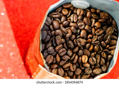 Gold Foil Coffee Bean Bag Isolated On Red Background. Coffee, Cheerfulness, Aroma