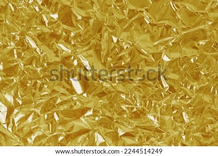Gold foil leaf shiny texture, abstract yellow wrapping paper for background and design art work.