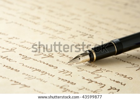 Gold Fountain Pen on Written Page. Crisp focus on nib of pen.