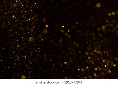 Gold glitter falling sparkle background on black