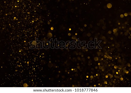 Gold glitter falling sparkle background on black