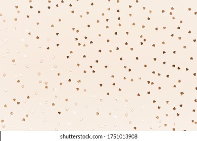 Gold Heart Confetti On Pastel Champagne Color Background. Festive Romantic Holiday Backdrop
