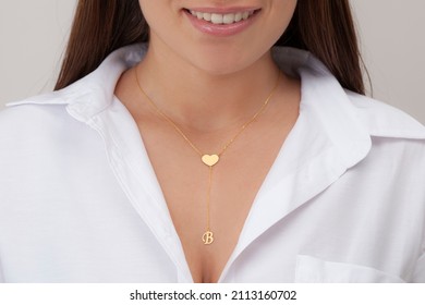 Gold Initial Necklace On Neck Of Attractive White Dress Girl. Personalized Necklace Image. Jewelry Photo For E Commerce, Online Sale, Social Media.