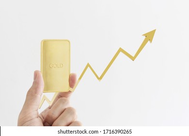 Gold Investment. Hand Holding Gold Bar With Raising Graph, Isolated On White Background