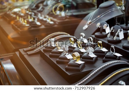 Gold jewelry diamond shop with rings and necklaces luxury retail store window display showcase 