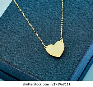 Gold jewelry. Heart necklace on background