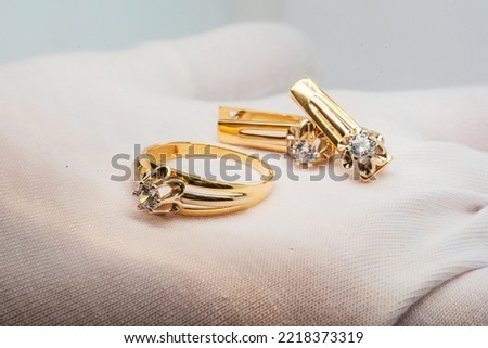 gold jewelry on the jeweler's hand. gold ring on a white glove. high quality gold jewelry. photos of gold jewelry for the catalog