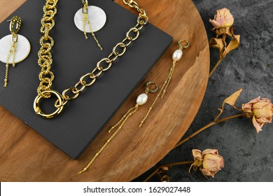 Gold jewelry on a wooden background. Jewelry for all lovers. chains on a wooden background. View from above.