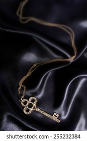 Gold Key Pendant On Black Silk