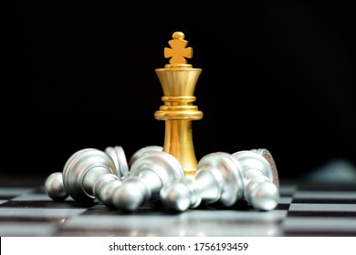 Gold King Chess Piece Win Over Lying Down Pawn On Black Background (Concept For Leadership, Crisis Management)