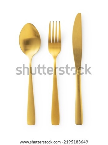 Gold knives, forks and spoons placed on a white background. Beautiful gold cutlery. View from above.